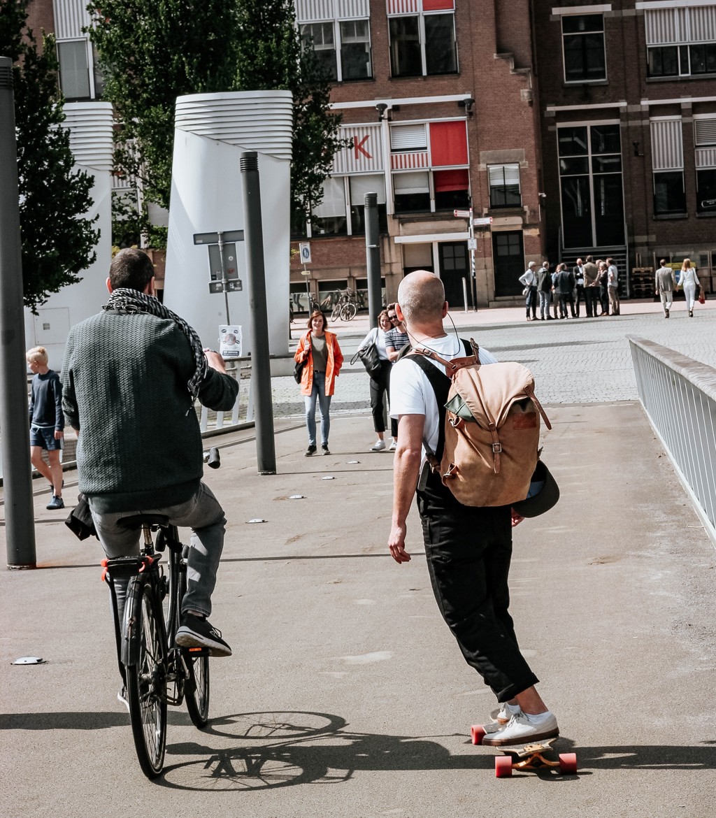 Twee vrienden in Rotterdam, waarvan één op de fiets en de ander op een skateboard Twee vrienden in Rotterdam, waarvan één op de fiets en de ander op een skateboard